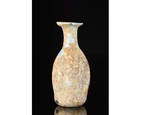 Ca. 100-300 AD. A beautiful glass flask with a long body displaying vertical grooves, a short, flared neck and a wide everted