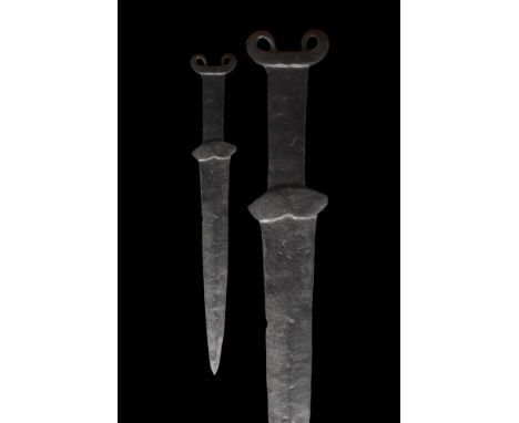 Ca. 500-400 BC. An iron sword with a broad tapering blade, which terminates in a point, rectangular grip with a lobed lower g