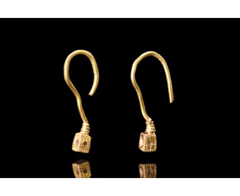 Ca. 100-200 AD. A nice pair of matched earrings crafted from gold, each earring features a round-section hoop with a cube fin