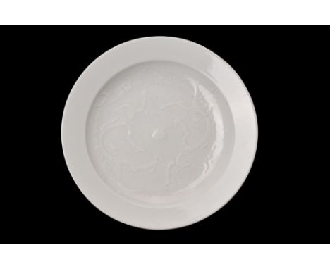 A porcelain shallow plate with crackled white glaze, which covers the entire surface of the plate, lending it a sense of simp