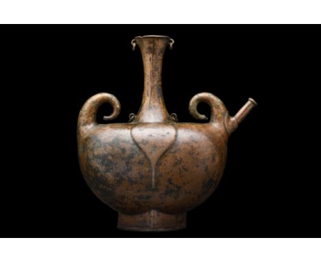 North India, Ca. 17th century AD. A Deccan Pilgrim flask, copper, with suspicion loops and elegantly curved finials. This fin