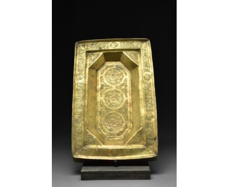 Ca. 1200 AD. A rectangular-shaped brass table-top tray with a wide lip and an octagonal central recess featuring three rounde