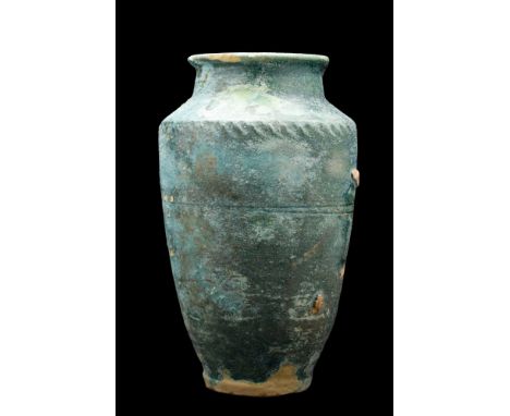 Kashan, Persia, Ca. 13th century AD. A classic pottery albarello jar with layers of intense turquoise glaze. The vessel rises