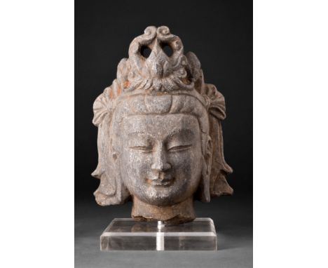 Sui Dynasty, ca. 581-618 AD or later. A stone head of a Bodhisattva depicted with a regal headdress and elaborately coiffured