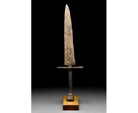 Ca. 13th-15th century AD. A short iron dagger with a broad blade tapering to a point. The cross guard straight, and a hilt fi