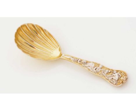 A Victorian silver parcel-gilt caddy spoon, Bacchanalian pattern, with a fluted bowl, maker’s mark partially lost in the flut