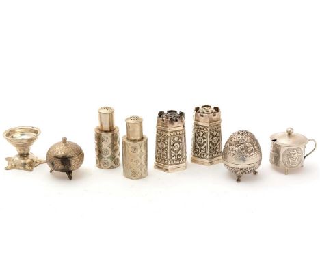 A pair of Chinese silver pepperettes; a silver plated mustard pot; a pair of Indian silver castle turret pepperettes; and thr