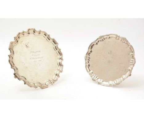 An Edwardian silver salver, of shaped circular outline with a shell and scroll border and an engraved coat of arms in the cen