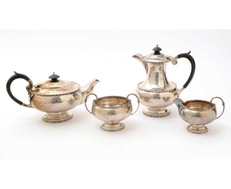 A George VI four-piece silver tea set with squat circular bodies, c-shaped handles and bobbin borders, by Walker &amp; Hall, 