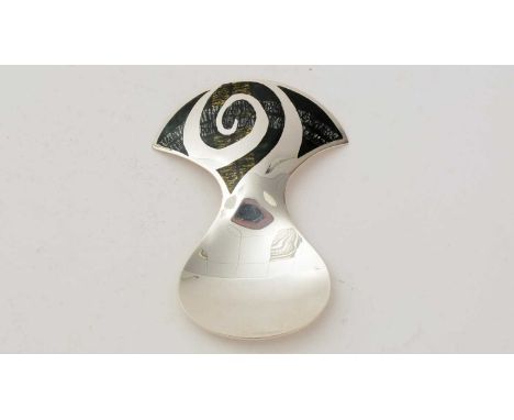 A contemporary silver caddy spoon, with a large axe-head shaped handle, decorated with a swirl of slate coloured enamel, high