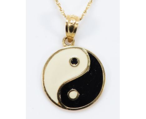 A 14k gold enamel yin yang pendant with a 14k gold chain, 13mm diameter, 1.5g