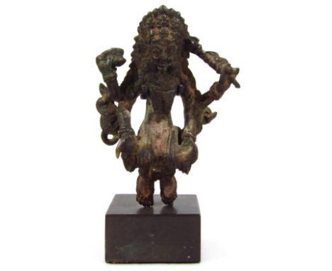 A Nepalese 16thC bronze figure of a Chamunda, modelled perched holding regalia, on a plinth, 13cm high.