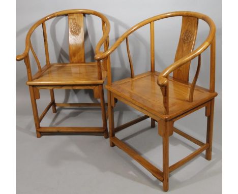 A pair of Chinese polished hardwood moon back chairs, each with shaped rails, scroll arms and vertical splats set with a shap