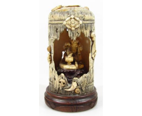 A 19thC Japanese ivory carved figure group, formed as an open vessel, heavily carved and raised on scrolls and pendants, with