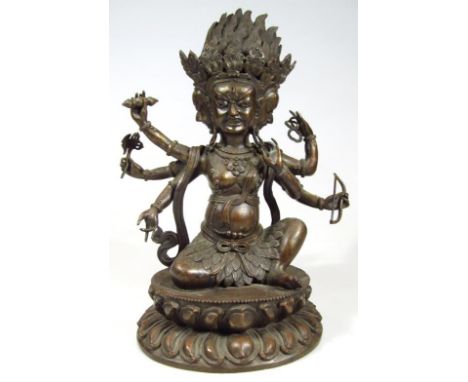 A Sino-Tibetan bronze late 18thC/early 19thC figure of Mahakala, modelled seated on a lotus flower with three heads and six a