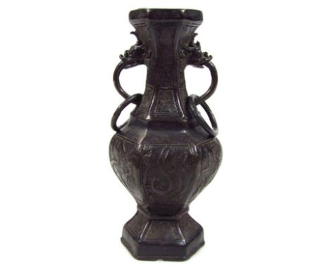 A 19thC Chinese bronze vase, of hexagonal outline with raised scroll and figural decoration and ring handles on a shaped foot