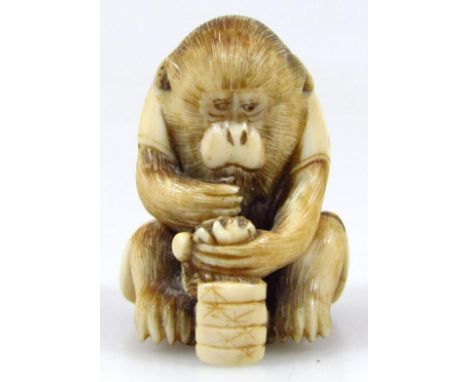 A Japanese Meiji period ivory netsuke, formed as a seated monkey in cloak, signed beneath, 2cm high. 