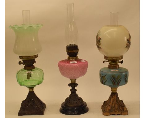 A late 19th/early 20th century spelter oil lamp, with green glass shade, and five others (6) 