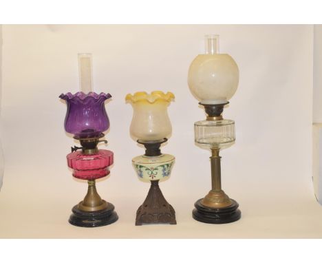 A late 19th/early 20th century glass oil lamp, with clear glass well, and five others (6) 