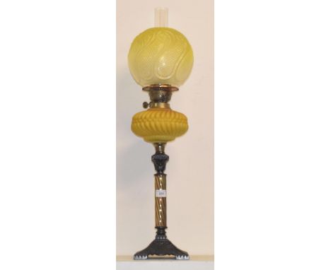 A late 19th/early 20th century oil lamp, with a yellow glass well, 78 cm highShallow chips to base of shade, no other faults 