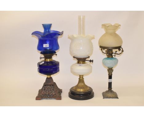 A late 19th early/20th century spelter oil lamp, with purple glass well, and five others (6)Oil lamp with blue glass well and