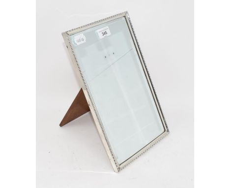 A rectangular silver easel table mirror, with a beaded edge, fitted a bevel edge plate and oak support, Walker & Hall, Sheffi