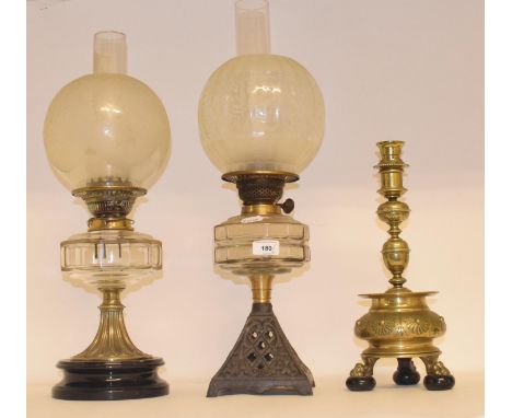 A late 19th/early 20th century brass oil lamp, with engraved glass shade, four other oil lamps and a brass candlestick (6) 
