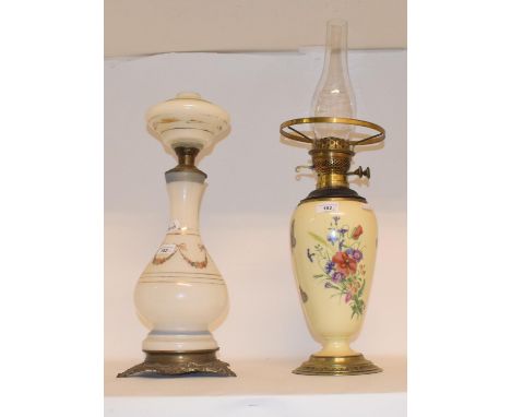 A 19th century porcelain oil lamp, decorated with flowers and butterflies, with gilt metal mounts, 43 cm high, and another (2