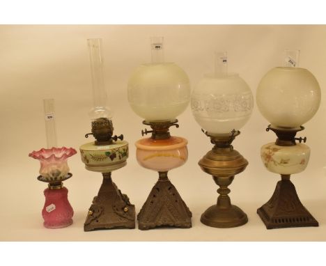 A late 19th/early 20th century brass oil lamp, with engraved glass shade, and eleven others (12) 