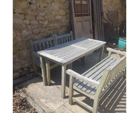 A teak garden table, a matching bench, and two armchairs (4) 