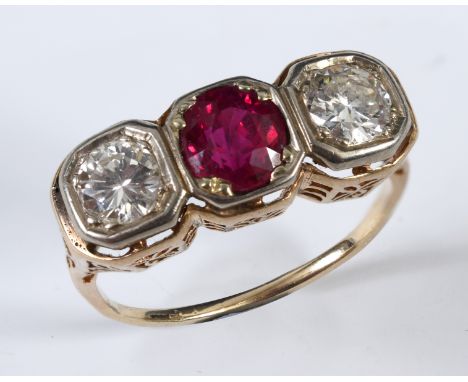 A yellow coloured metal ring, set a ruby flanked by two diamonds, in a pierced setting, apparently unmarked, approx. ring siz