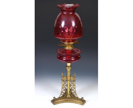 A late 19th/early 20th century brass oil lamp with ruby glass well, 70 cmShallow chips  to base of shade otherwise no other m
