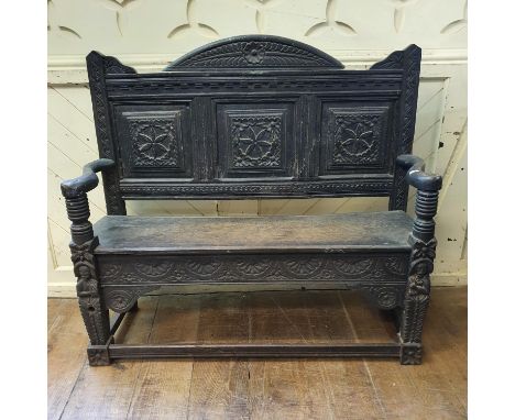 An oak bench, carved figures, flowers and lunettes, 117 cm wide 