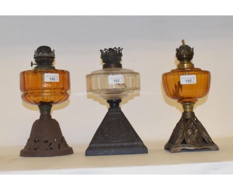 A late 19th/early 20th century spelter oil lamp, with pink glass well, and eight other oil lamps (9) 