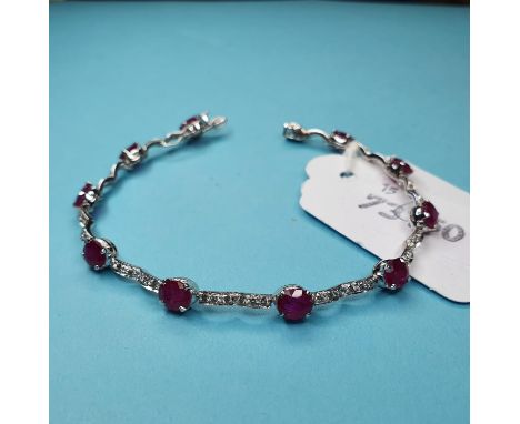 A Burmese ruby and diamond fancy link bracelet, in a white coloured metal settingTen rubies, 18 cm long 