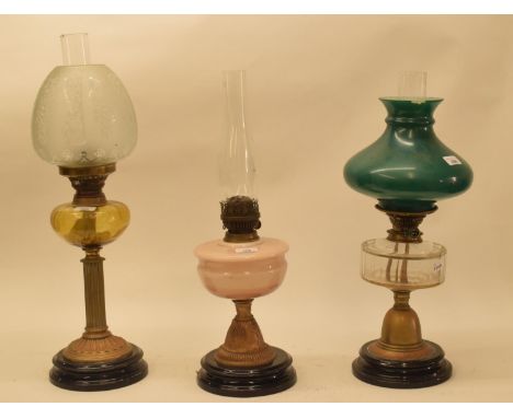 A late 19th/early 20th century brass oil lamp, with clear glass well, and five others (6) 