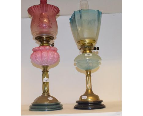 A late 19th/early 20th century oil lamp with pink glass well, 68 cm high, and another (2)Both shades with chips red shade cra