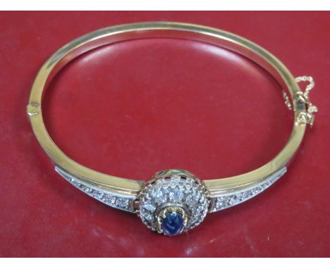 UNHALLMARKED GOLD SNAP BANGLE SET WITH CENTRAL BLUE SAPPHIRES SURROUNDED BY TWENTY DIAMONDS 