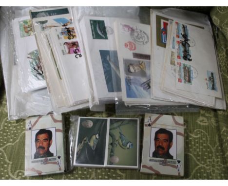 Two packs of Saddam Husayn Al-Tikriti playing cards and a collection of First Day Covers
