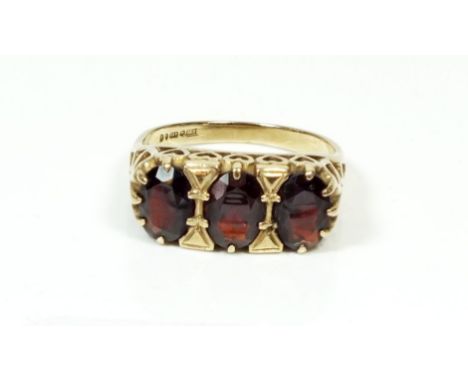 A 9 carat gold three stone garnet ring, size M