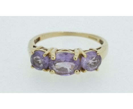 A 9 carat gold three stone amethyst ring - size N.