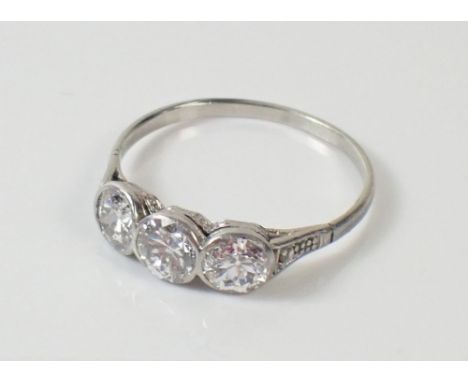 A white gold or platinum set three stone diamond ring, Size N 