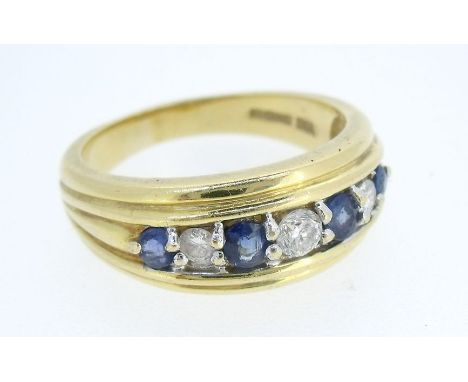 An 18 ct gold ring set three diamonds and four sapphires 6.8g, size B