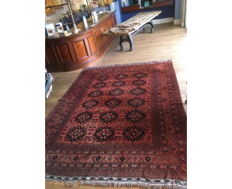 An Afghan carpet, with 3 rows of 6 medallions within a wide multiple border, 336 x 260cmCondition report: Fringes ragged with