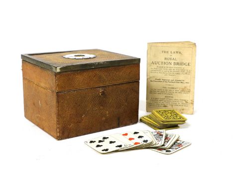 A leather card box, c.1900, the hinged top with a ring of enamel playing cards within a patinated metal border, the sectional