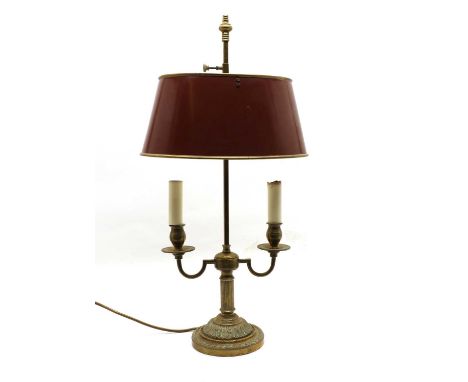 A French brass bouillotte-style table lamp, 20th century, with a red toleware shade and twin branches, above a fluted column 
