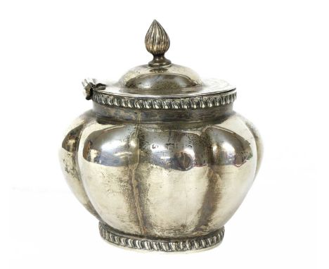 An oval, lobed, silver tea caddy, London 1902, with a flame finial hinged cover and gadroooned borders, the cover engraved 'p