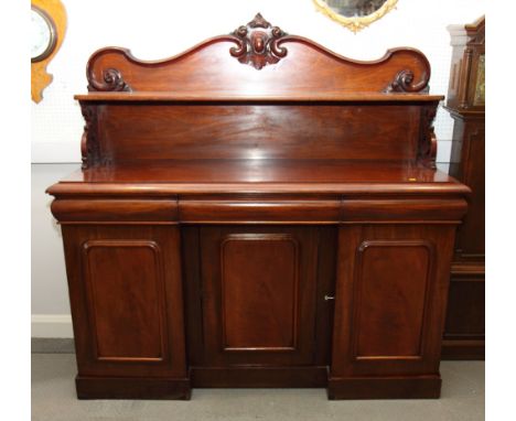 A 19th Century mahogany sideboard with ledge back, on breakfront base enclosed three arch panel doors