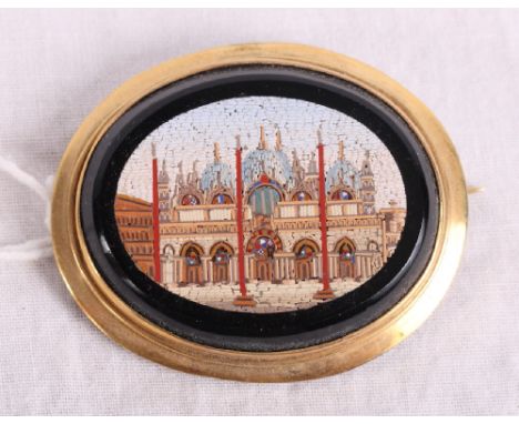 A 19th Century oval micro mosaic panel decorated view of St Mark's Square with black border and gilt metal brooch mount