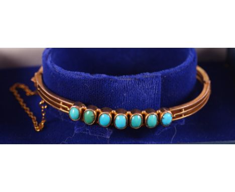 A late Victorian 9ct gold bangle set seven turquoise cabochons, 6.5g